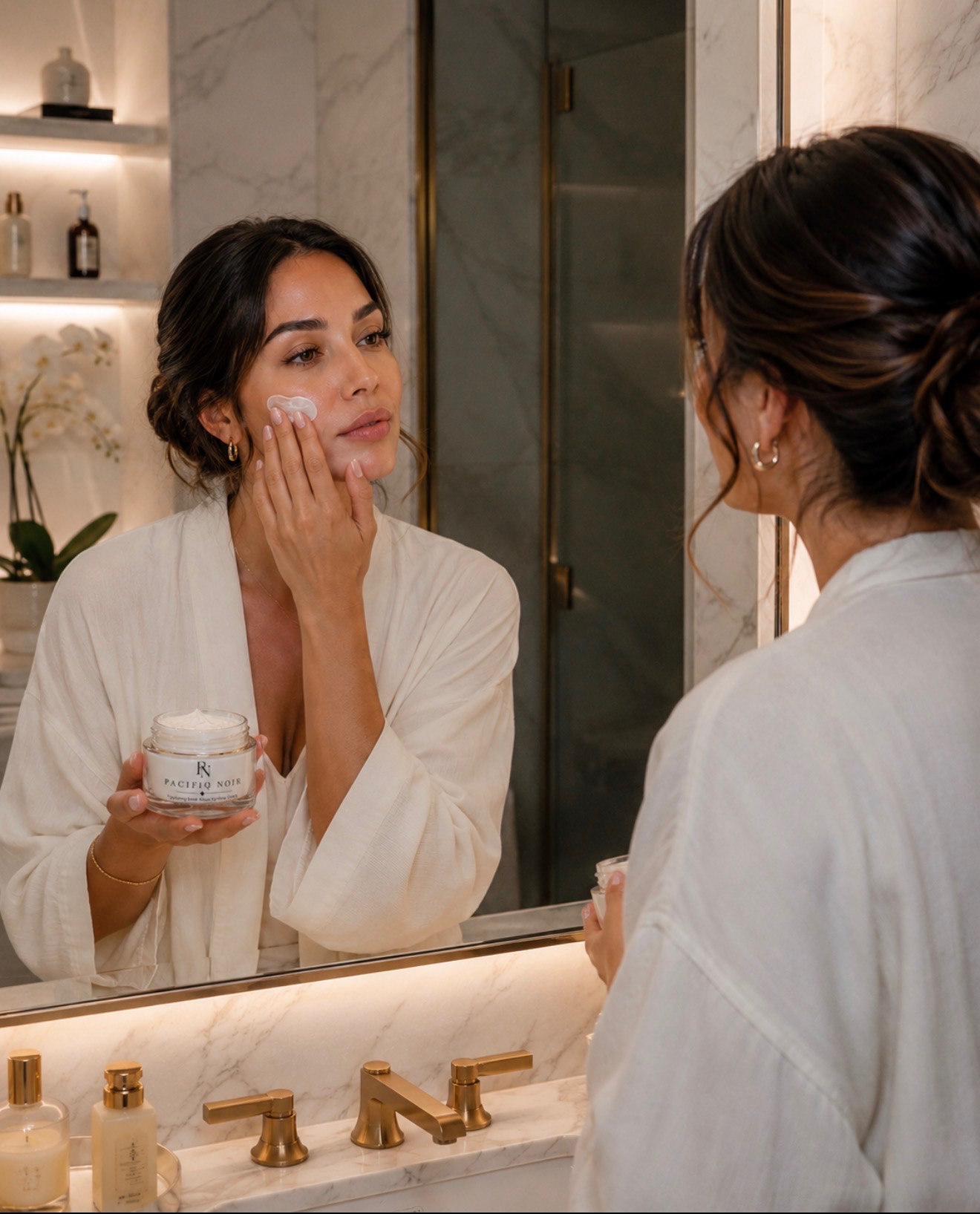 A woman applying PACIFIQ NOIR™ crème as part of her luxury skincare ritual
